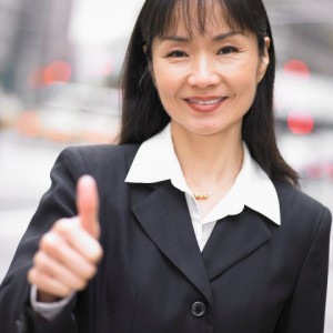 Businesswoman giving thumbs up --- Image by © Royalty-Free/Corbis