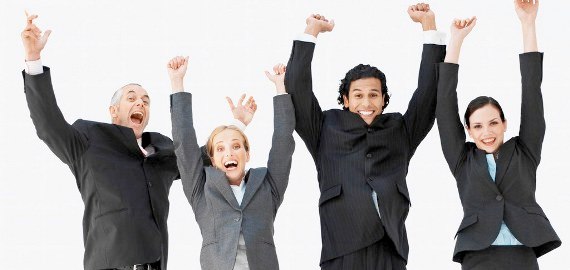 Front view portrait of four business executives jumping with arms raised --- Image by © Royalty-Free/Corbis