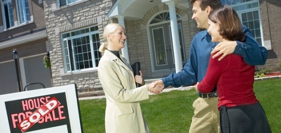 REALTOR with couple, shaking hands
