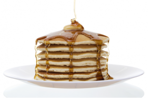 stack of pancakes with syrup pouring over the top