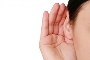 an ear with a hand cupped around it, listening
